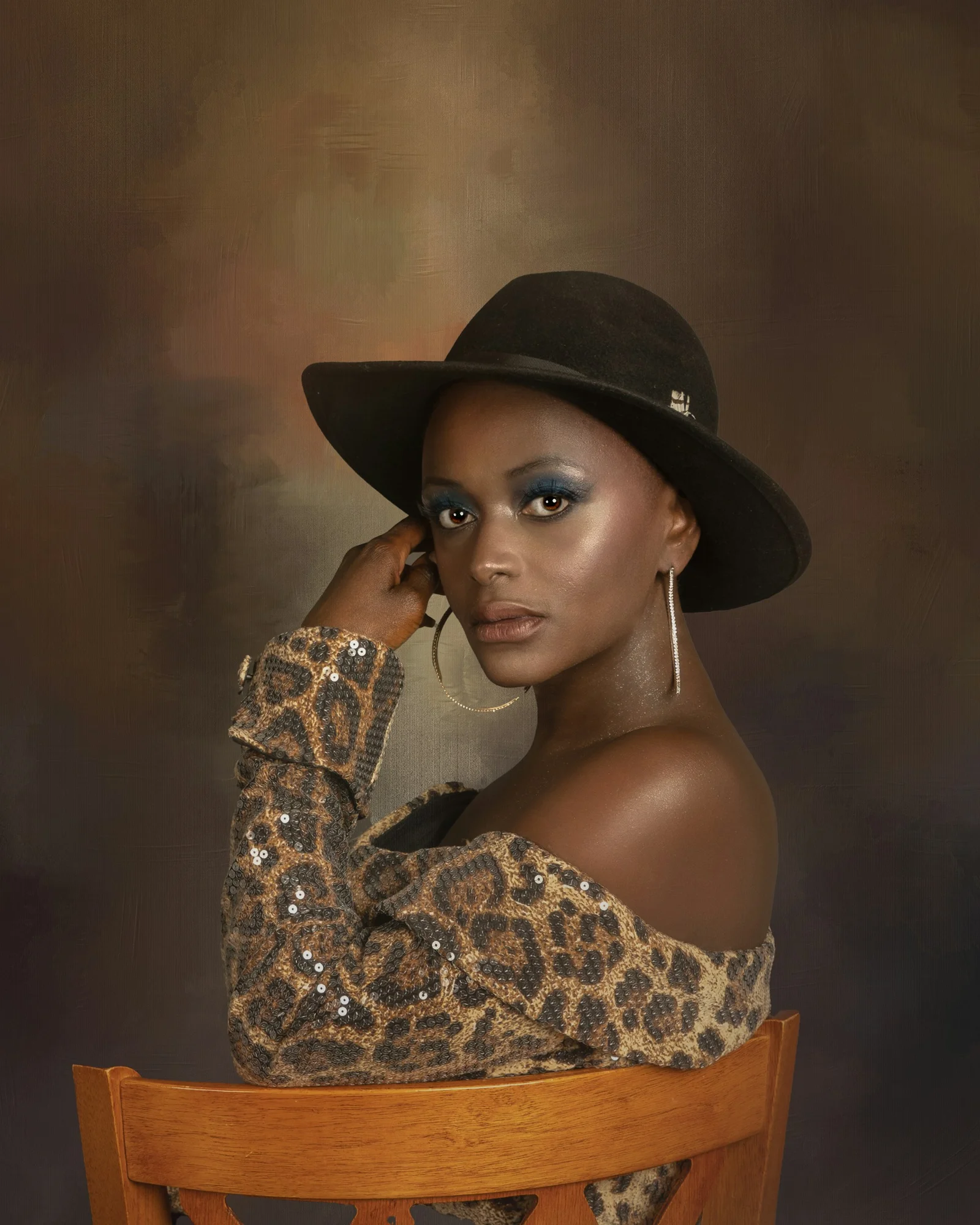 a woman wearing a leopard print shirt and a black hat