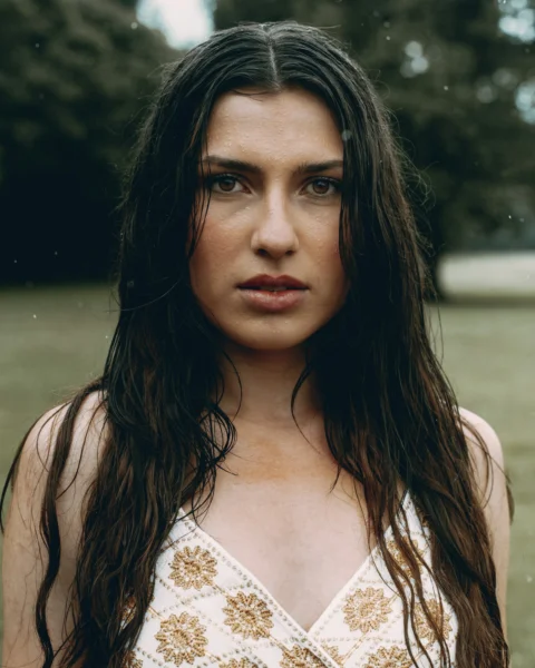 A woman with wet hair gazes intensely