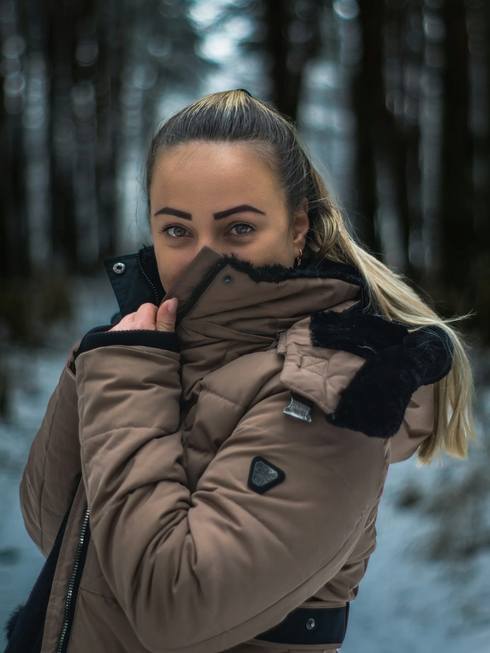 a woman with a ponytail is standing in the snow