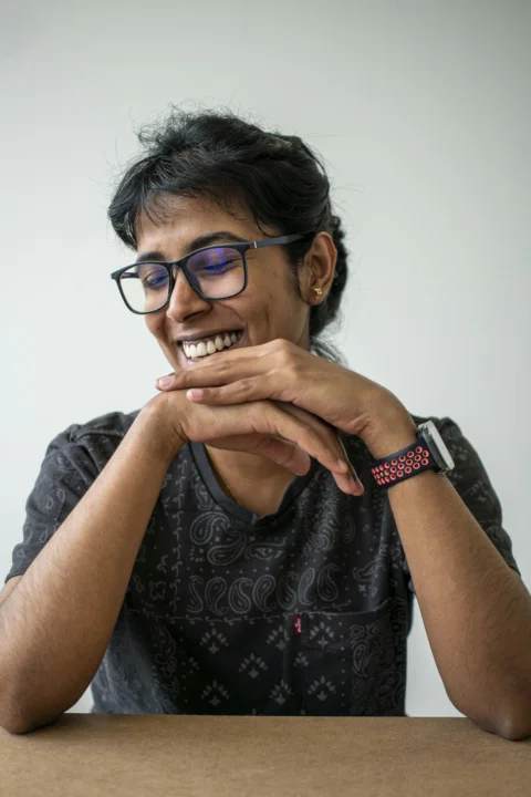 A smiling woman leans on her hands