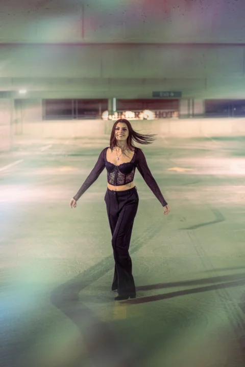 a woman in a black outfit skating on an ice rink