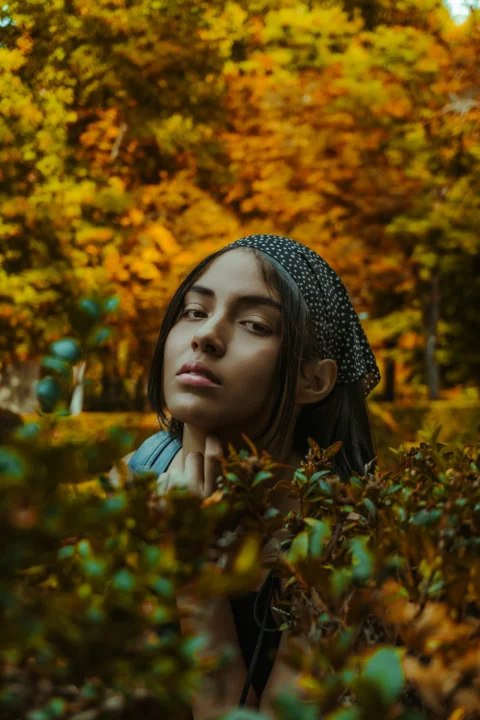 a woman with a headband standing in a forest