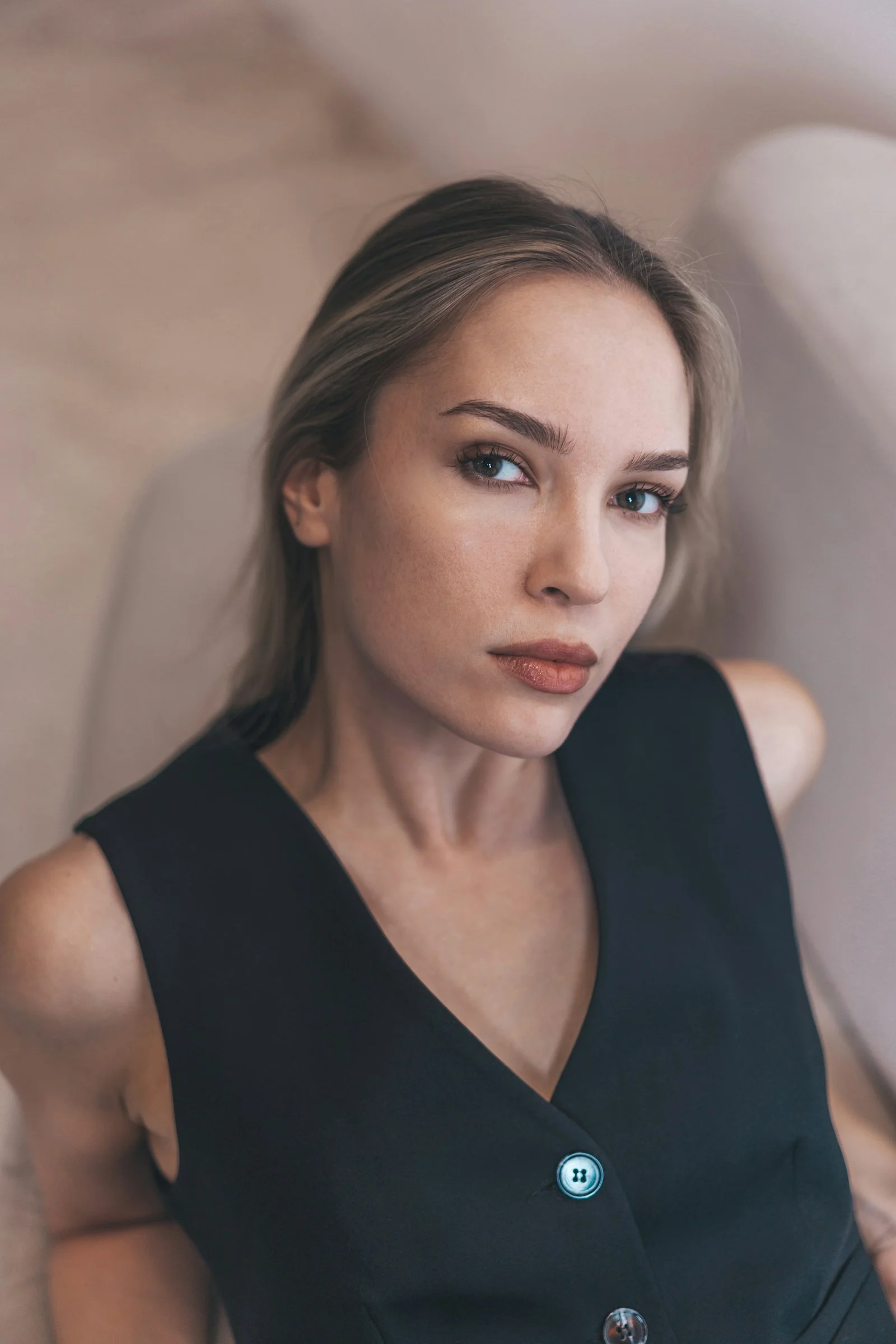 A woman in a black vest looks at the camera