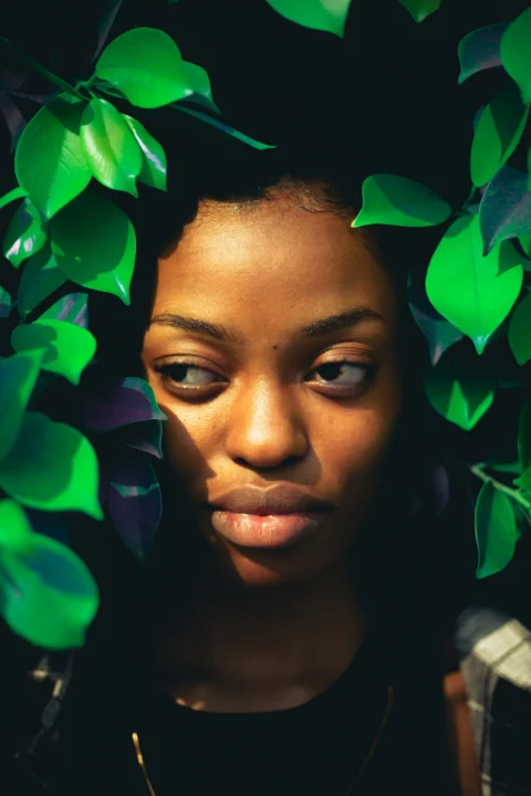 A woman with green leaves on her head