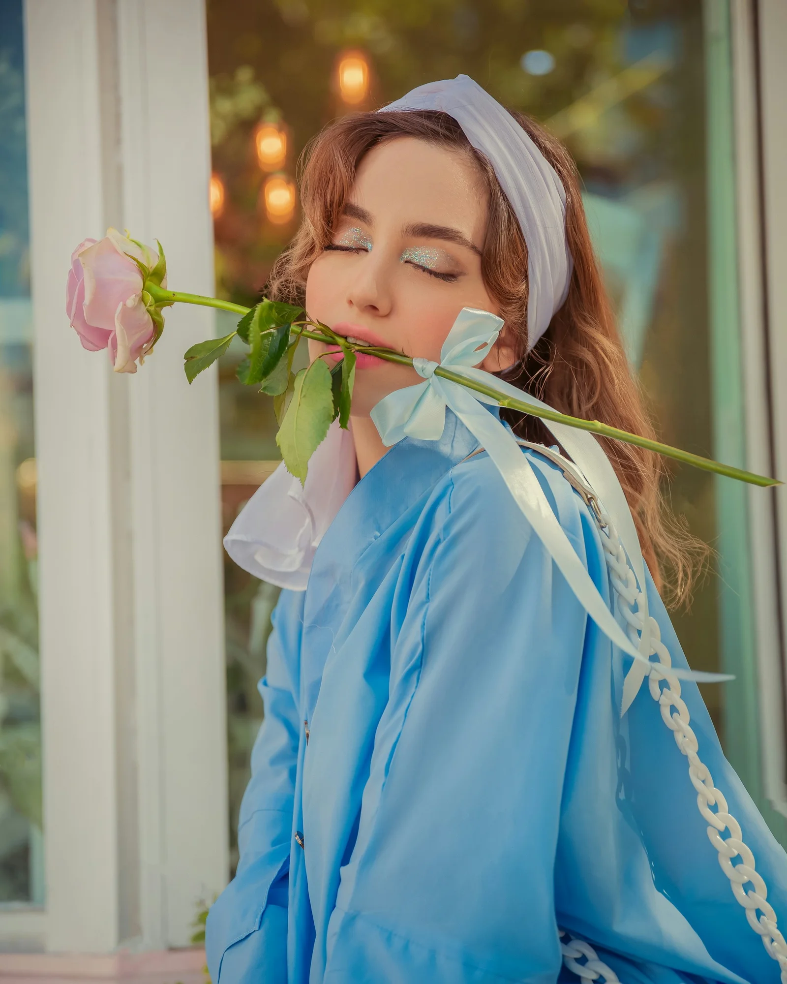 a woman in a blue dress holding a rose