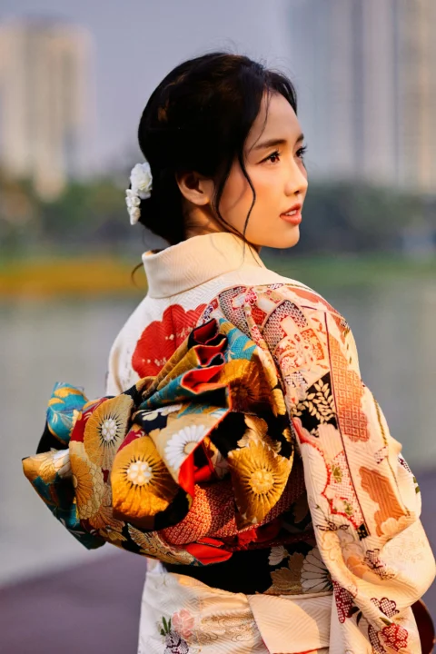 Woman in traditional japanese kimono with a floral obi outdoors