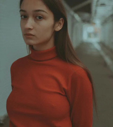 一名穿红色衬衫的女子站在走廊里