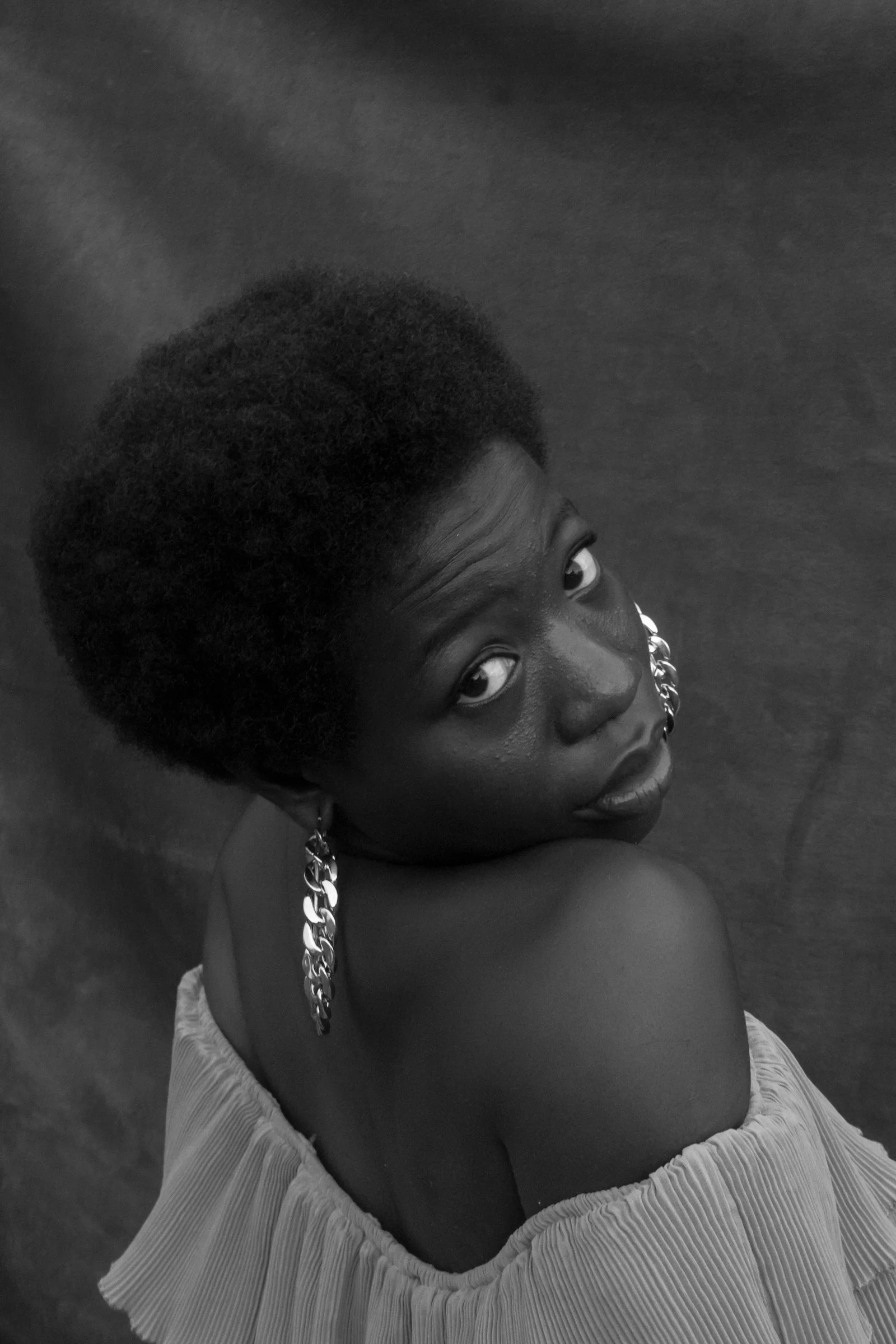 a woman with an afro is posing for a picture