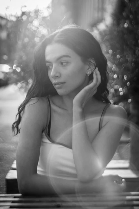 Young woman with dark hair and bright lens flare