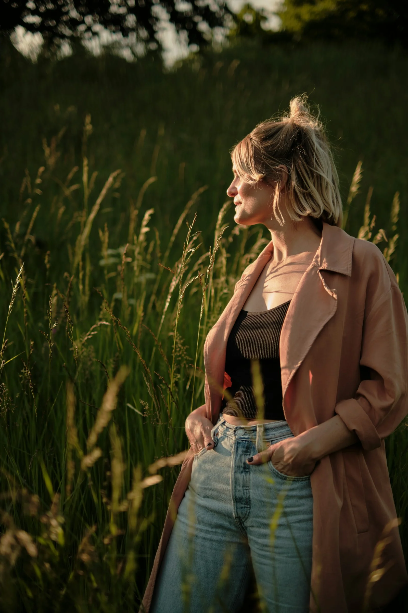 a woman standing in a field of tall grass