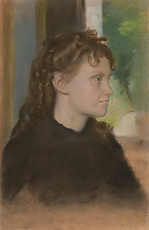 Young woman with red curly hair in profile