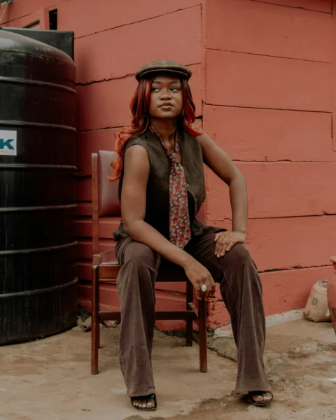 Stylish woman sits outside, posing for a portrait