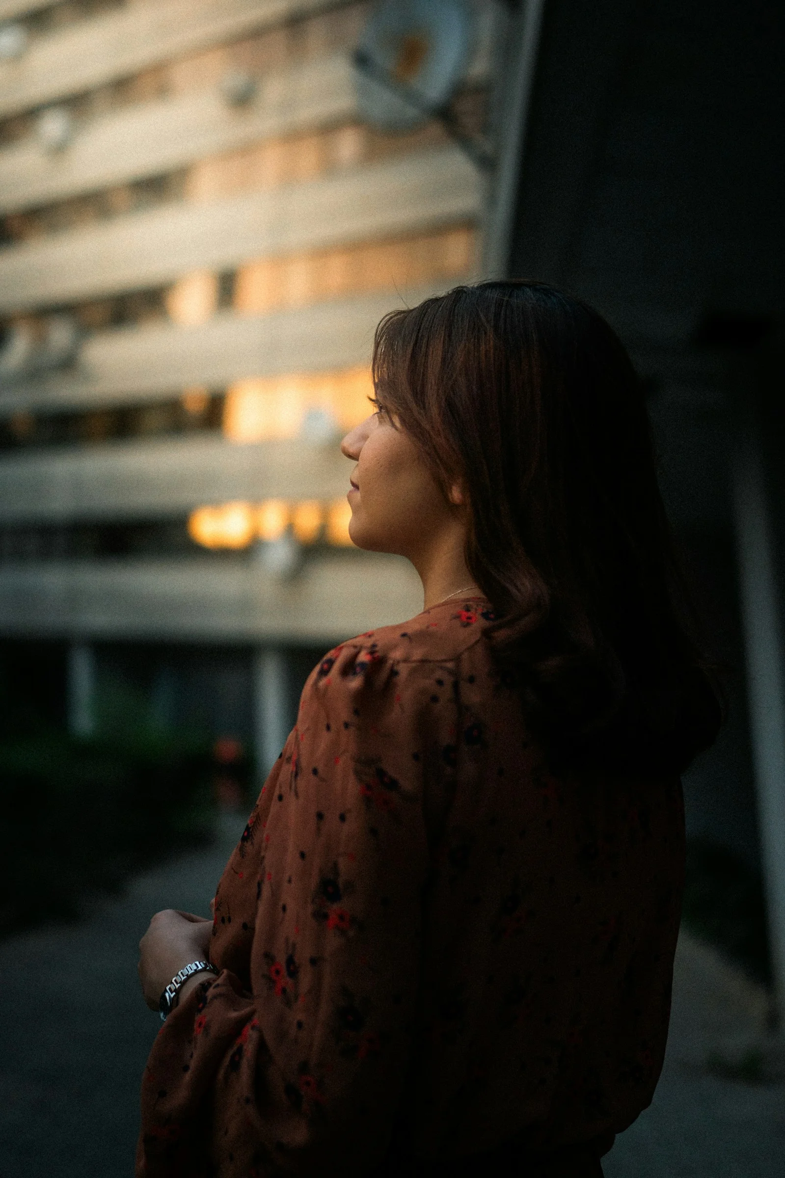 在渐暗的光线中女子望向一座建筑