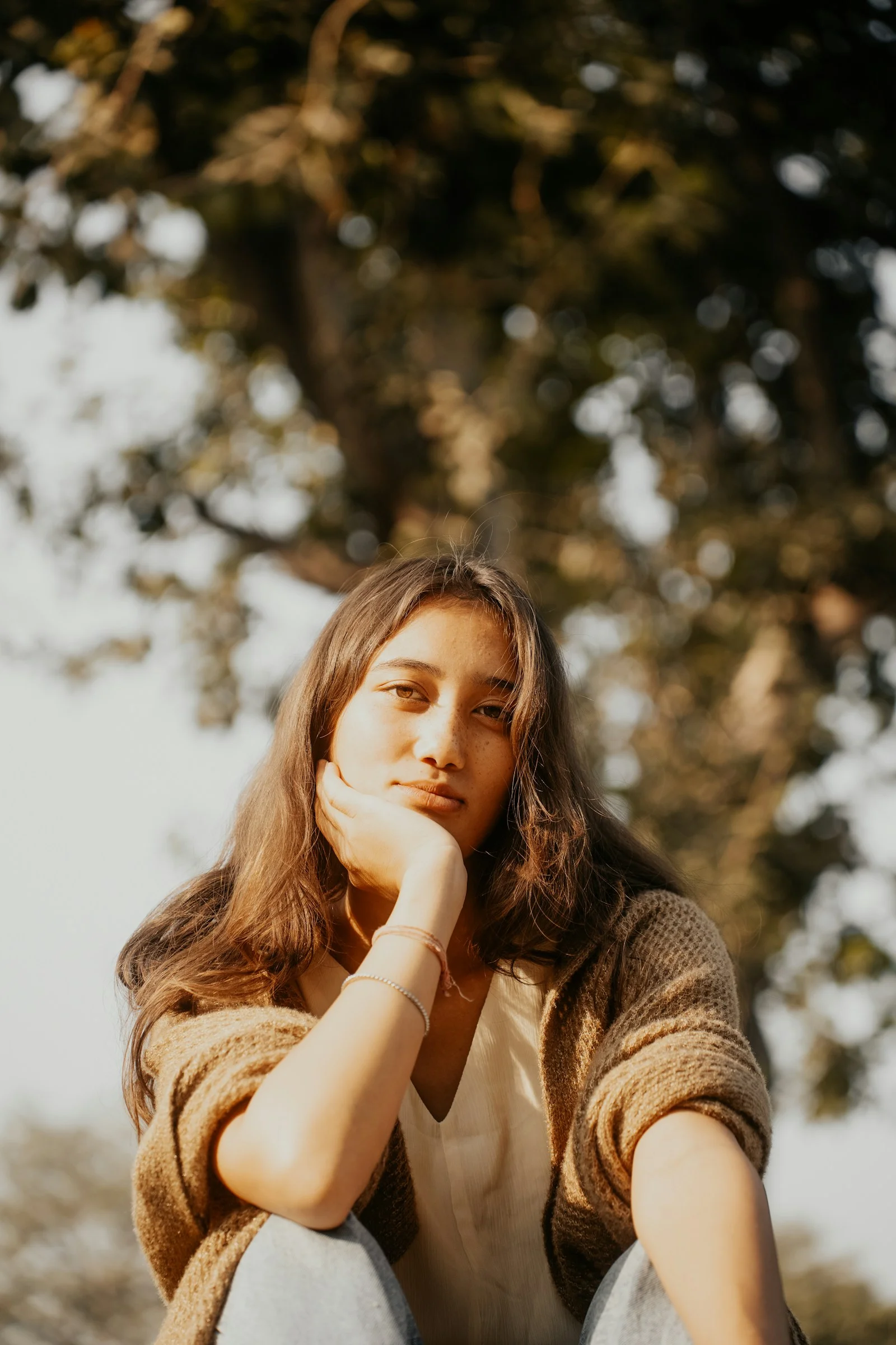 A young woman sitting on top of a wooden bench
