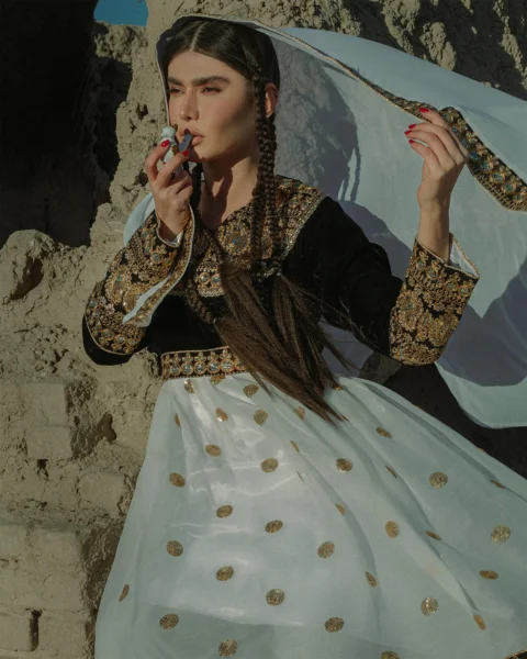 a woman in a long white dress holding an umbrella