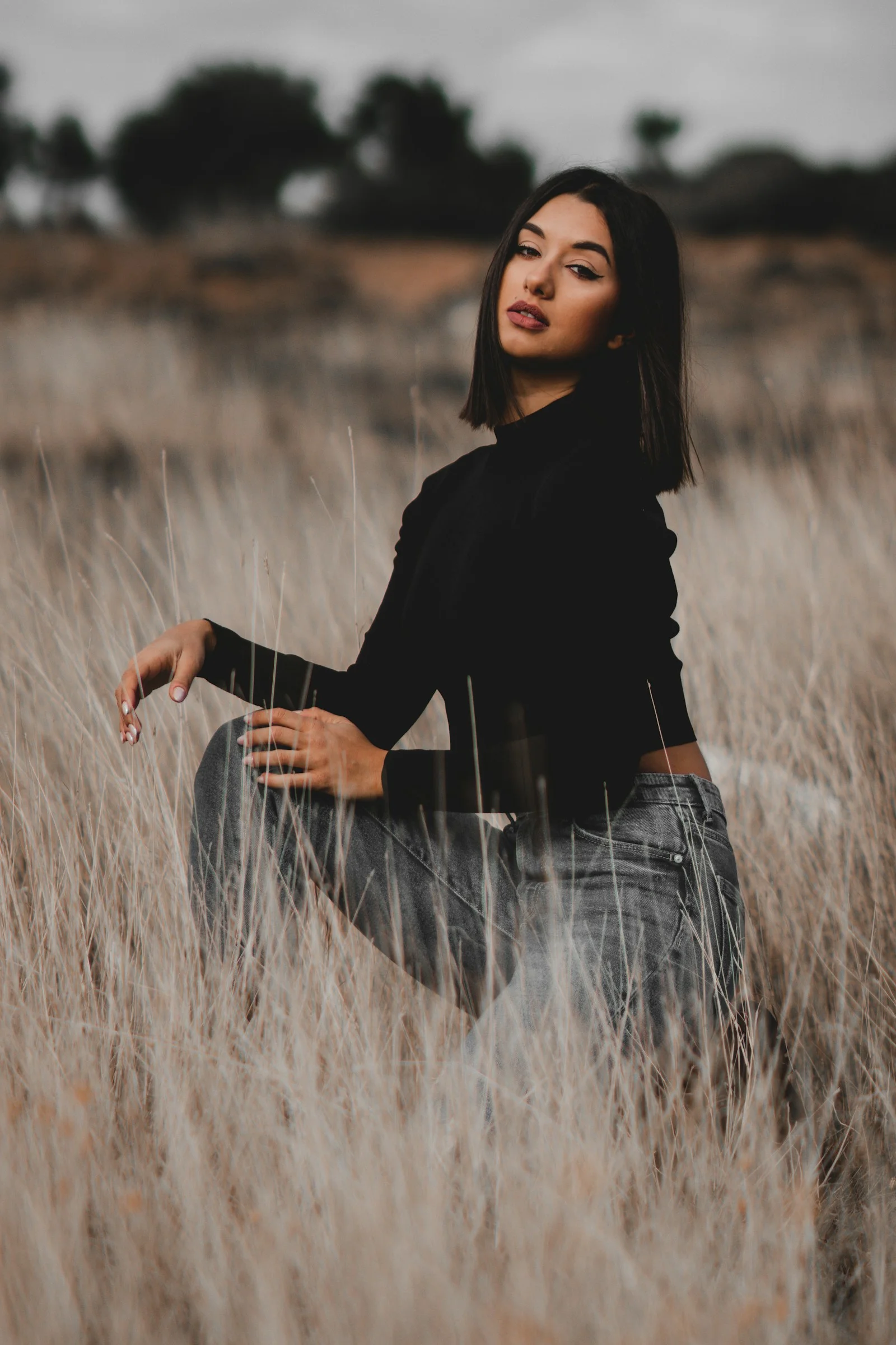 a woman sitting in a field of tall grass