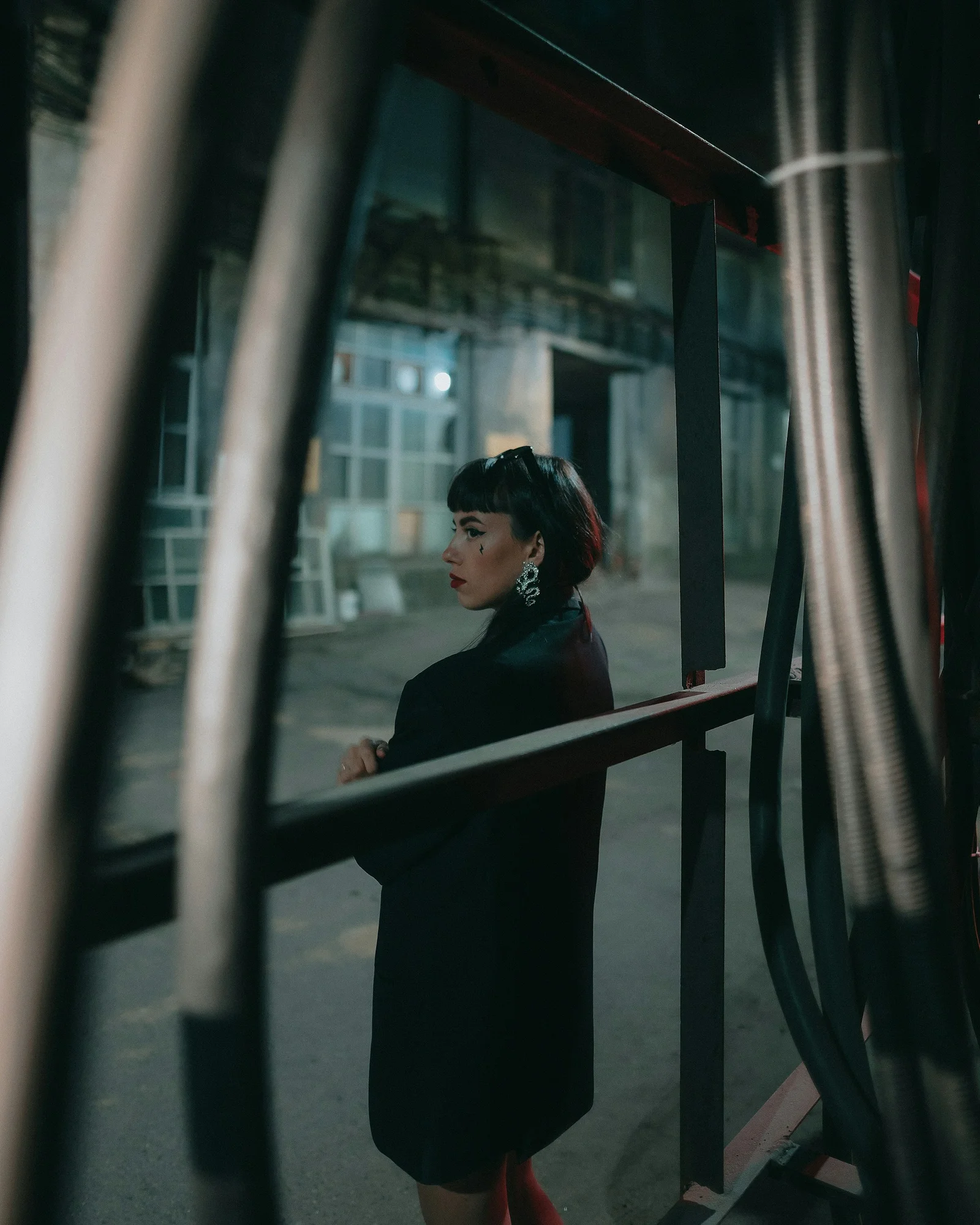 a woman in a black dress standing by a window