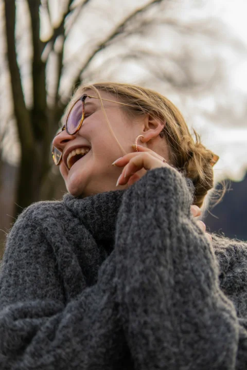 a woman with her eyes closed laughing