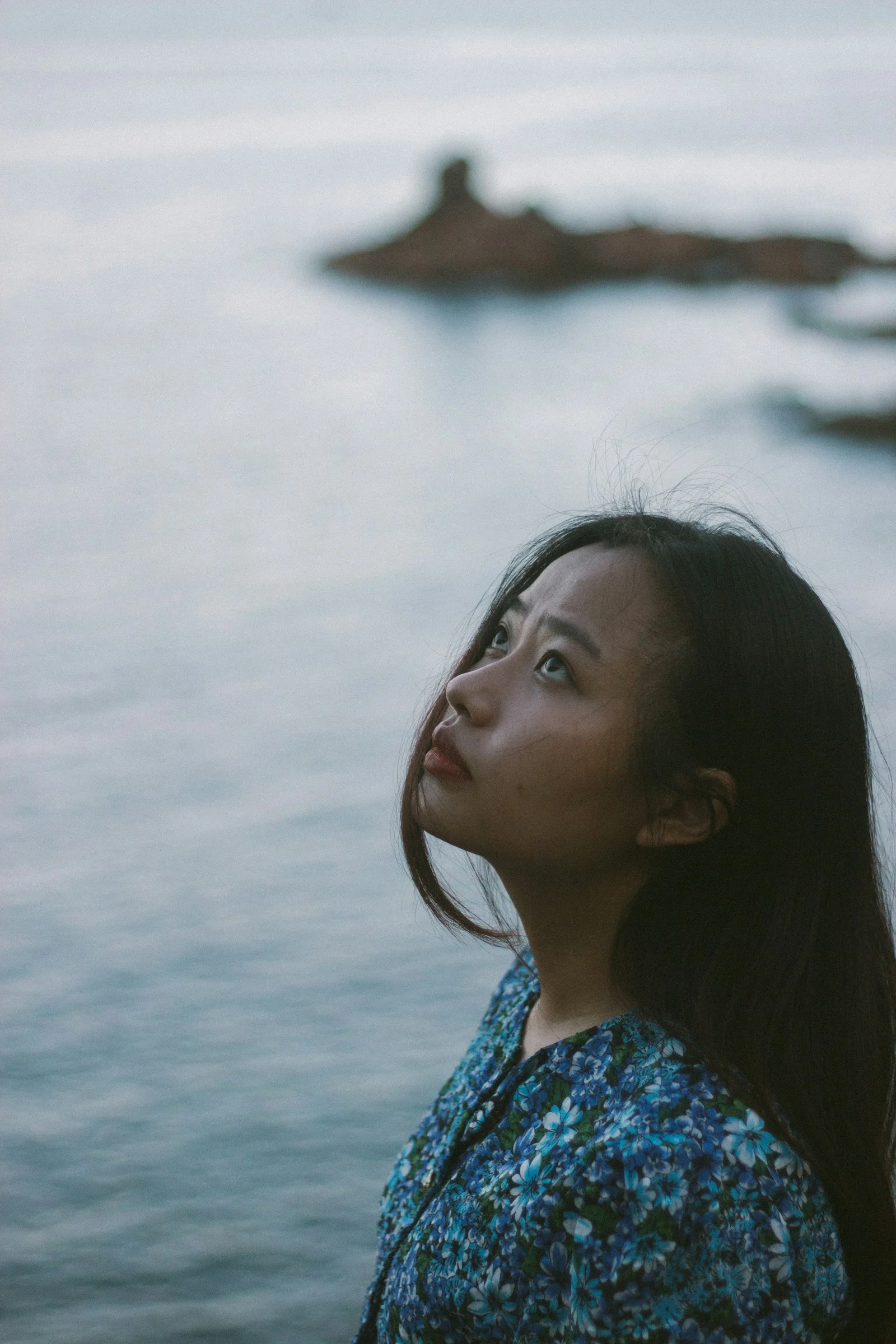 a woman standing in front of a body of water