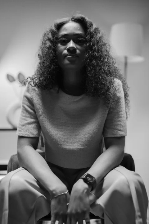 a black and white photo of a woman sitting on a chair