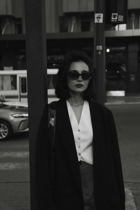 一个女人站在人行道上的一根杆子旁