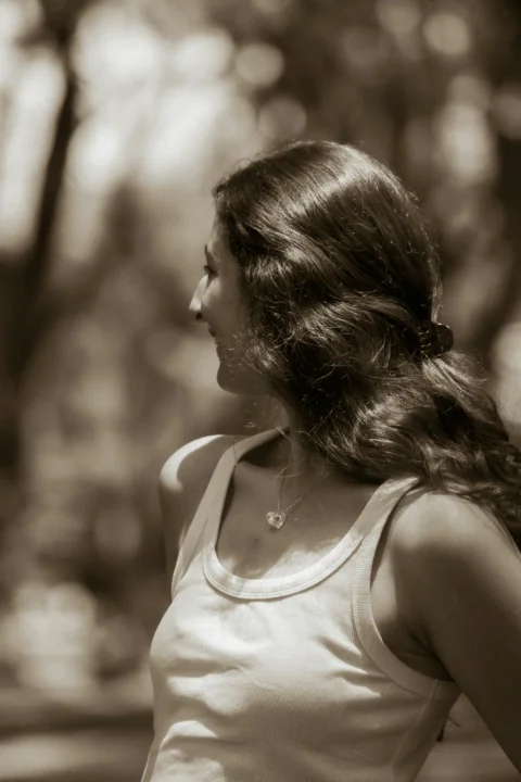 A woman with long hair looking right in sepia tone