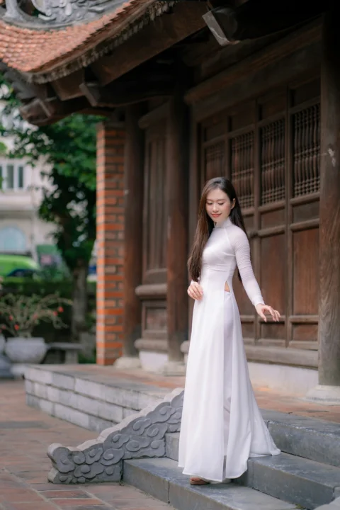 一位女子在寺庙旁身穿白色奥黛
