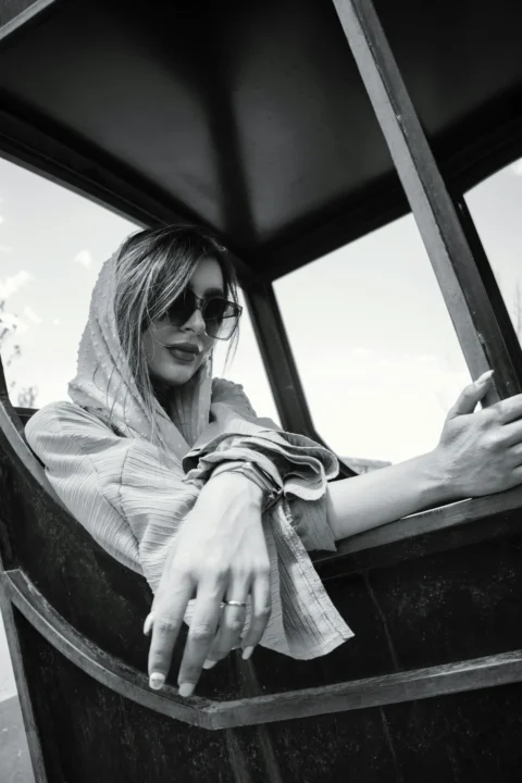 a woman in sunglasses is sitting in a boat