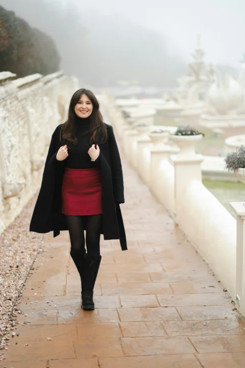 A woman in a red dress is walking down a path