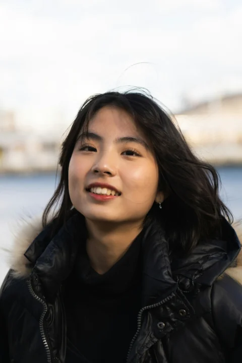 一名穿黑色夾克的女人對著鏡頭微笑