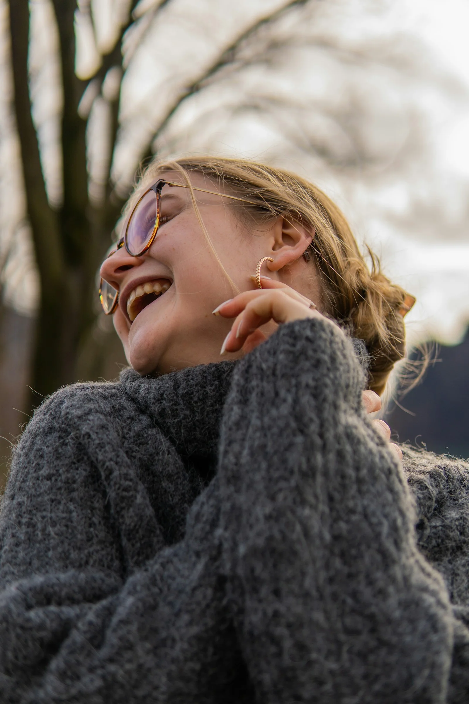 a woman with her eyes closed laughing