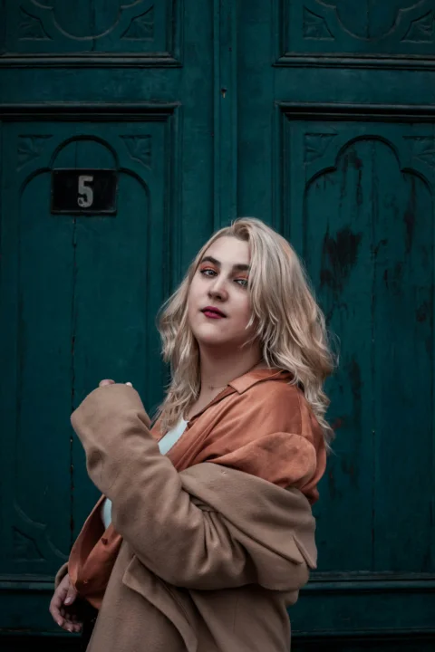 a woman standing in front of a green door