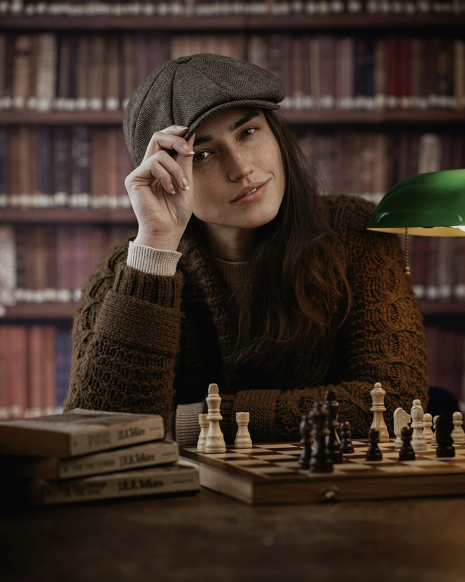 一名坐在摆有国际象棋棋盘的桌旁的女子