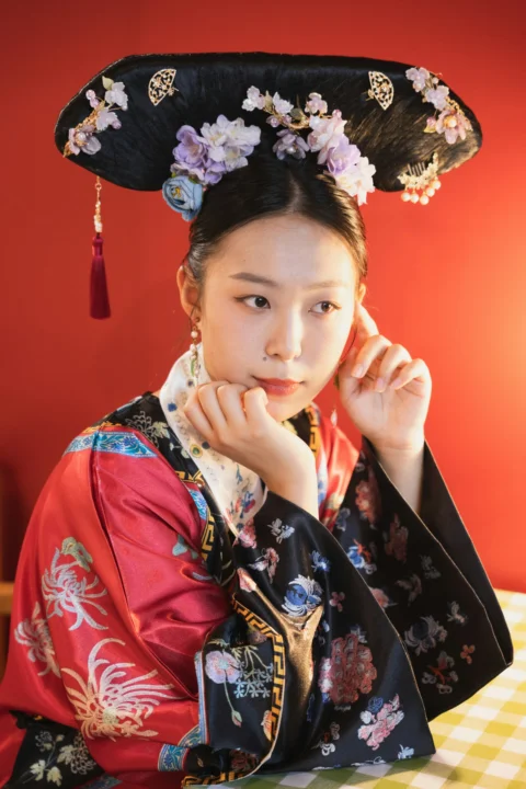 a woman wearing a black hat with flowers on it