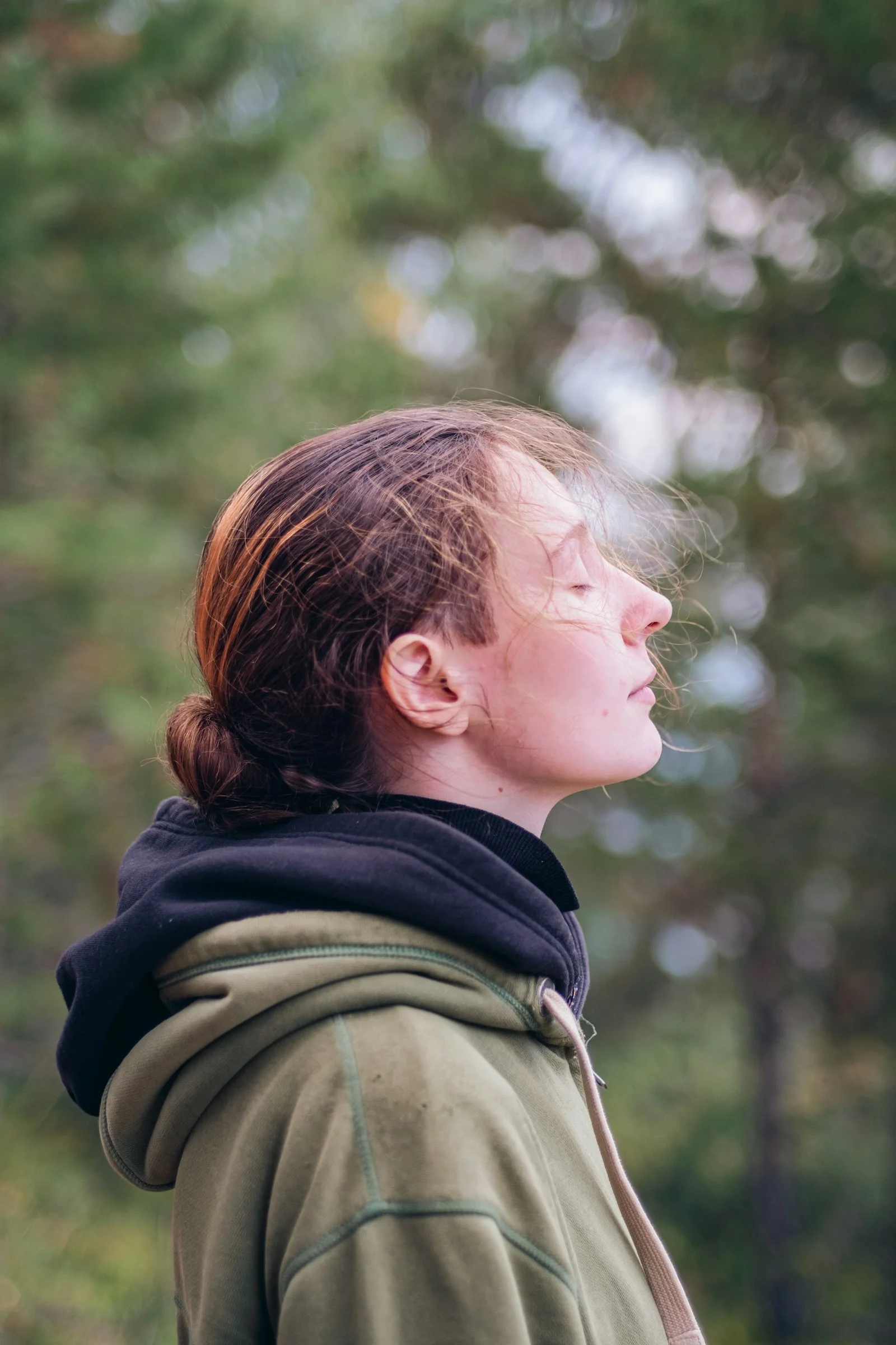 a woman standing in front of a forest