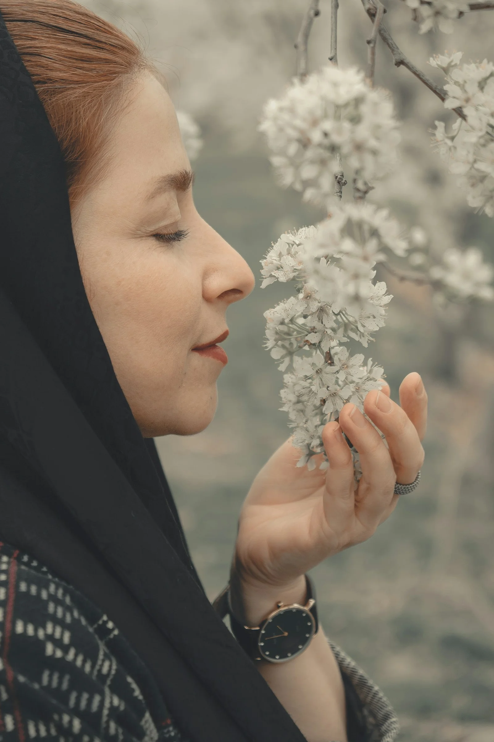 woman in black hijab holding white flower