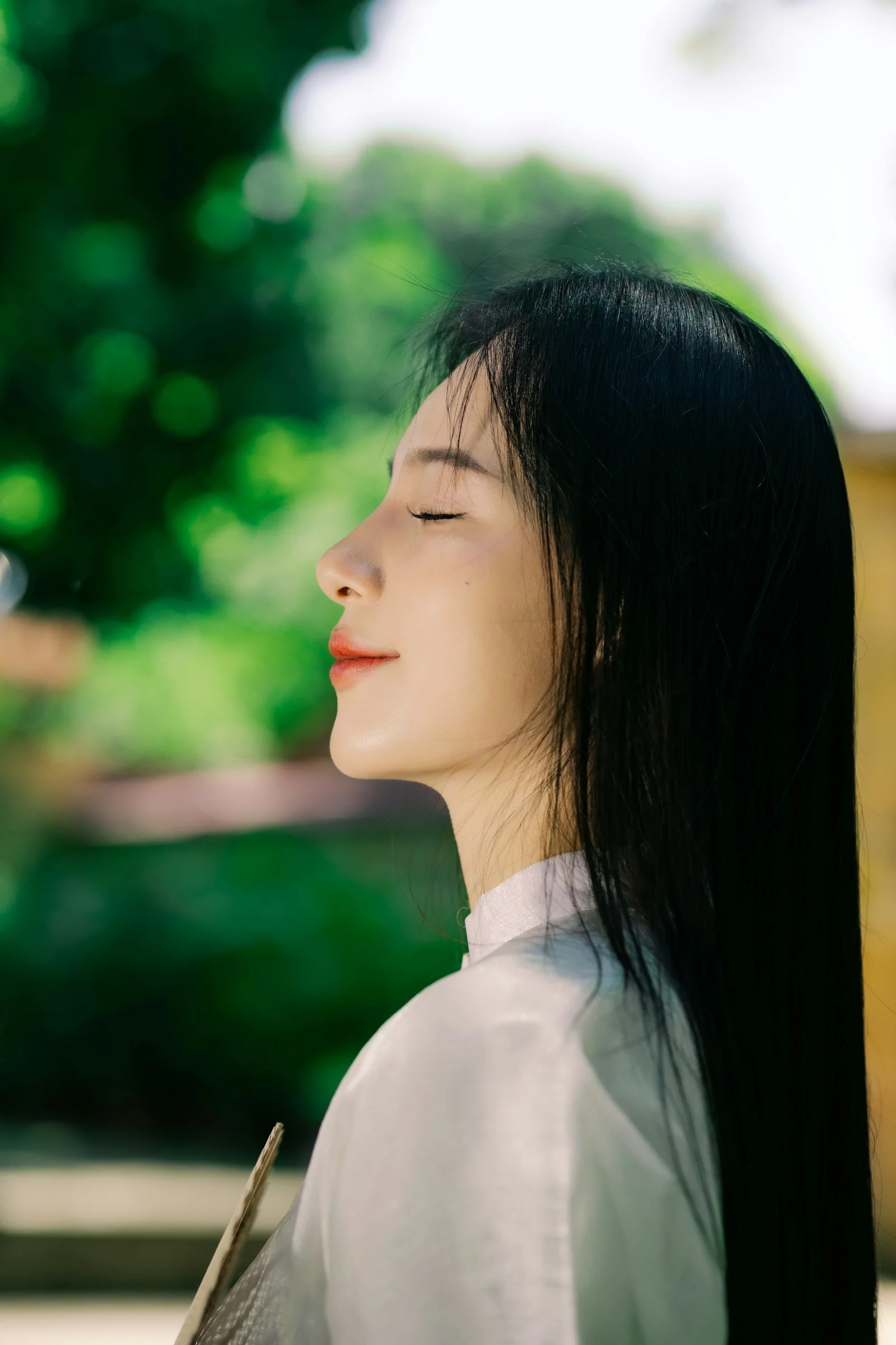 긴 검은 머리카락과 흰색 셔츠를 입은 여성