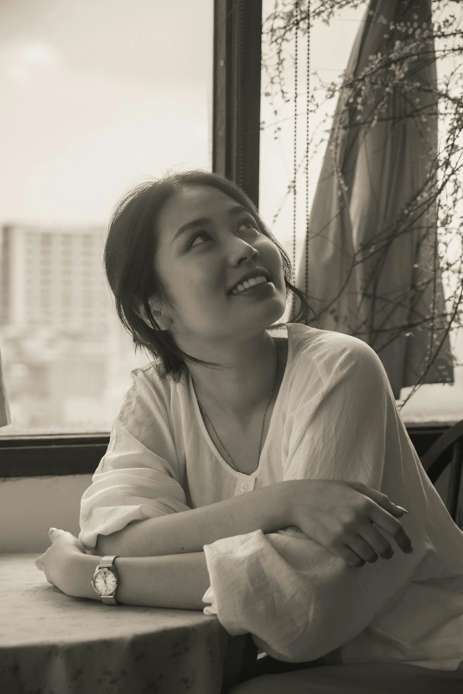 穿白衬衫仰头望向窗户的女人