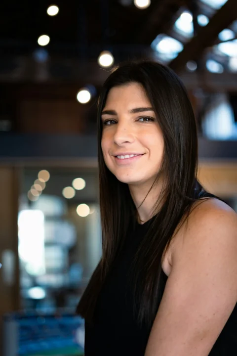 a woman in a black dress smiling at the camera