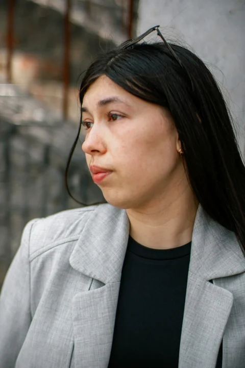 A woman looks away with glasses on head