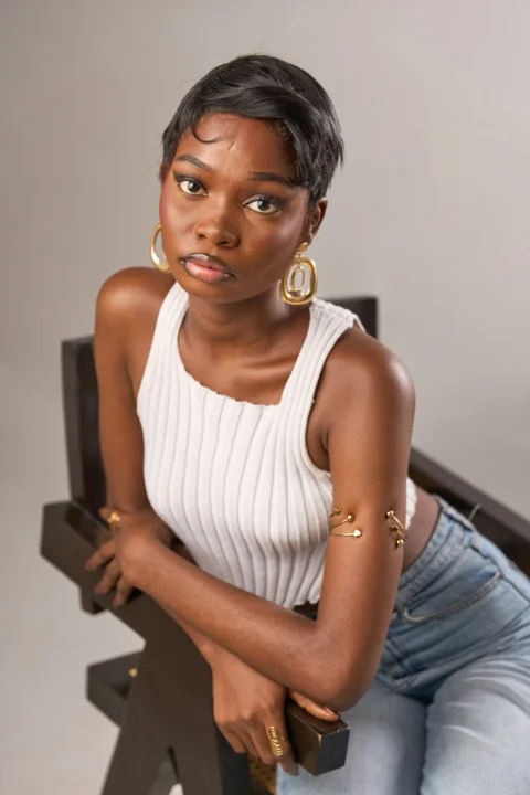 Young woman in white top and jeans with gold jewelry