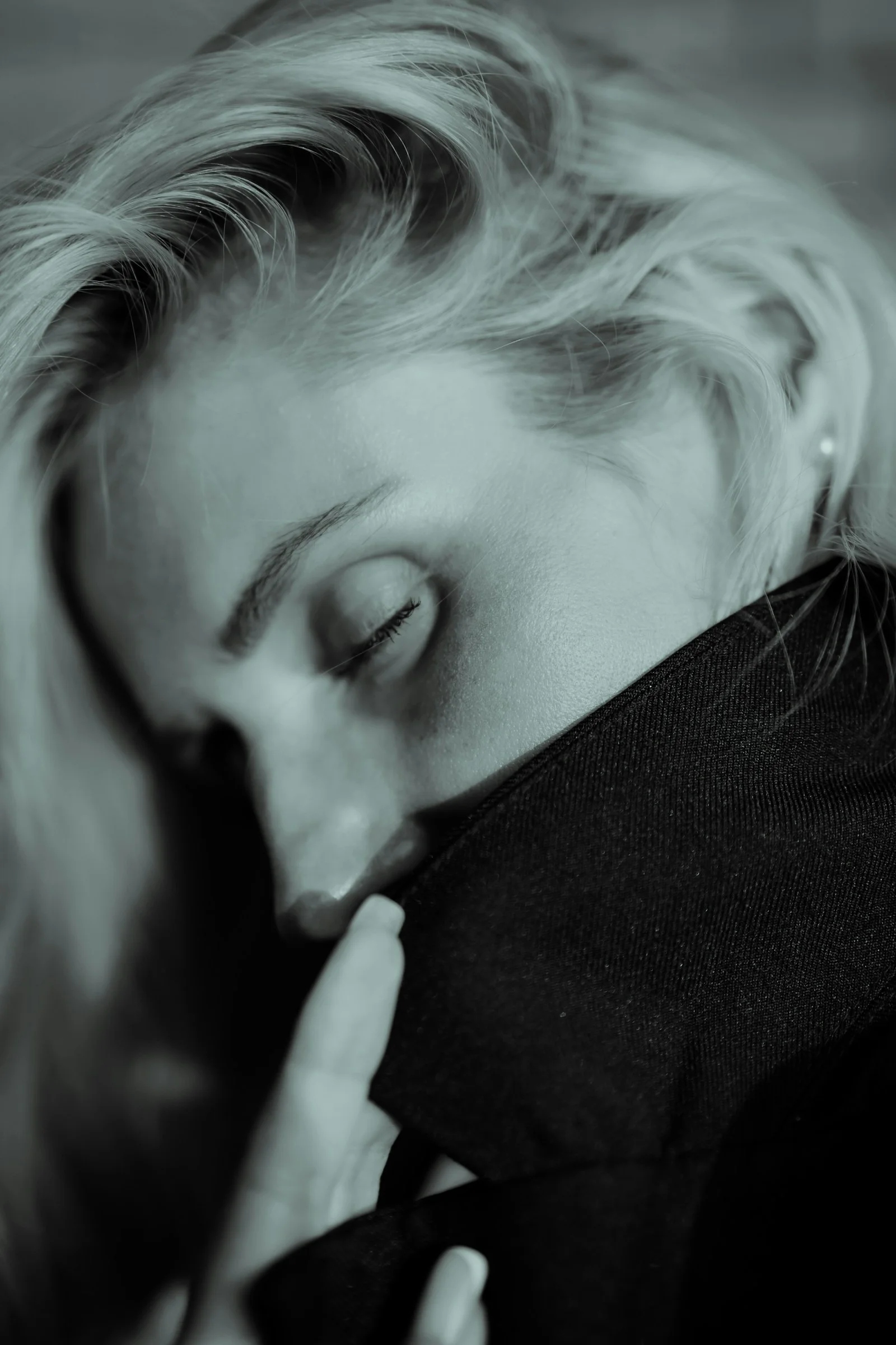 a black and white photo of a woman with her eyes closed