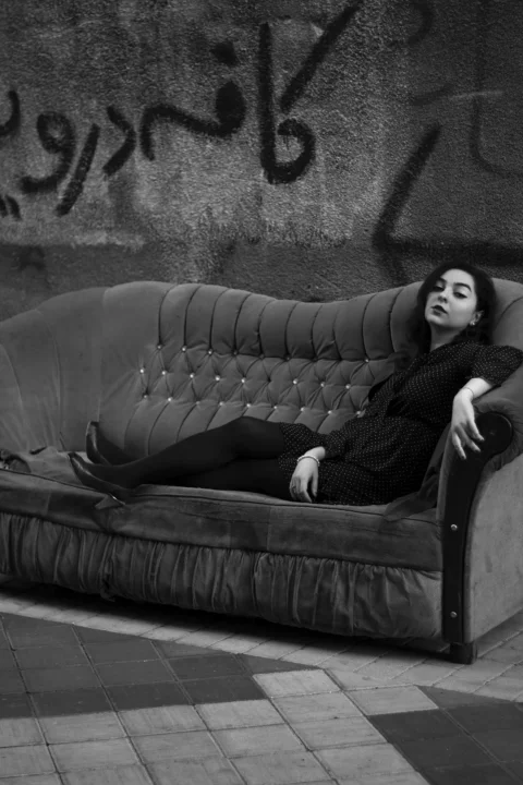 a woman laying on a couch in front of a wall