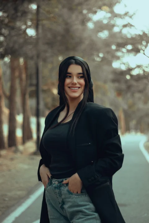 a woman standing on the side of a road