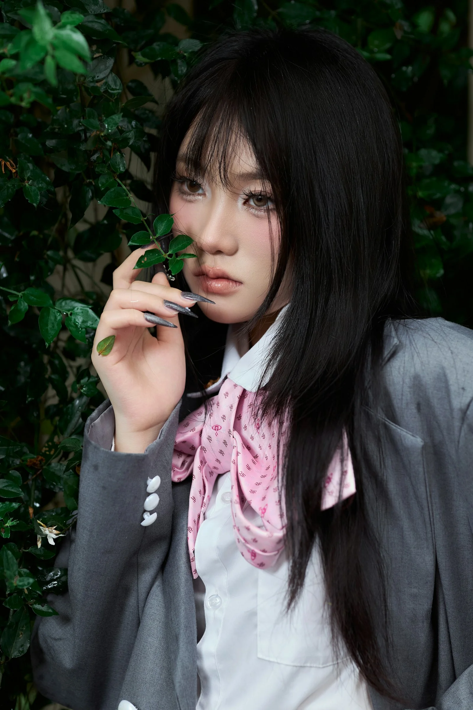 Young woman in school uniform holding a leafy branch