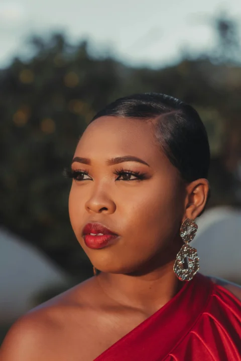 a woman in a red dress with large earrings