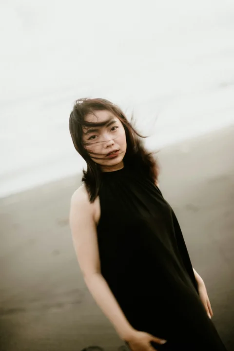 a woman standing on a beach next to the ocean