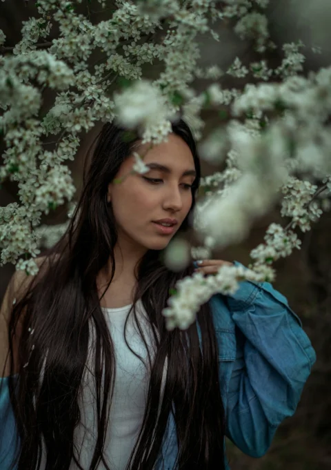 A beautiful woman posed amongst blossoming flowers