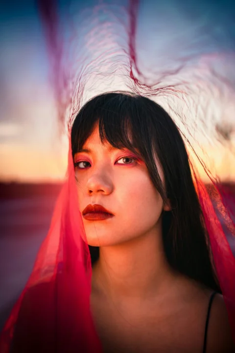 赤い口紅と白・赤の布を身にまとった女性