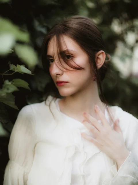 Young woman with hand on chest in nature